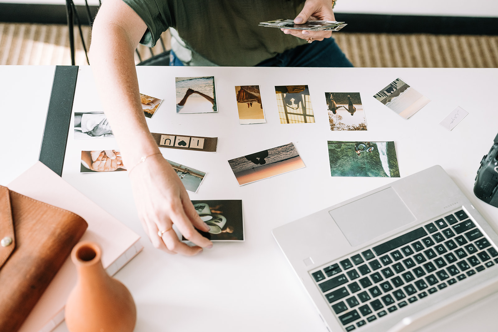 Hannah arranging printed photographs on a desk
