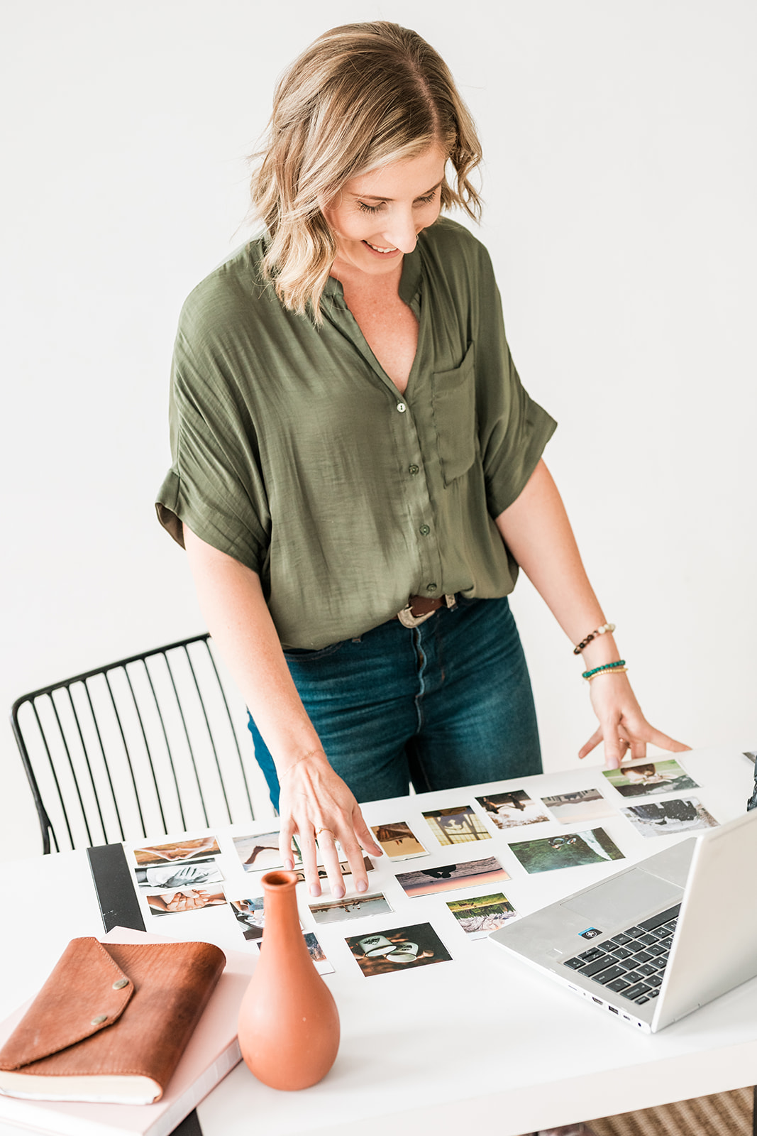 Hannah reviewing printed photographs at her studio desk