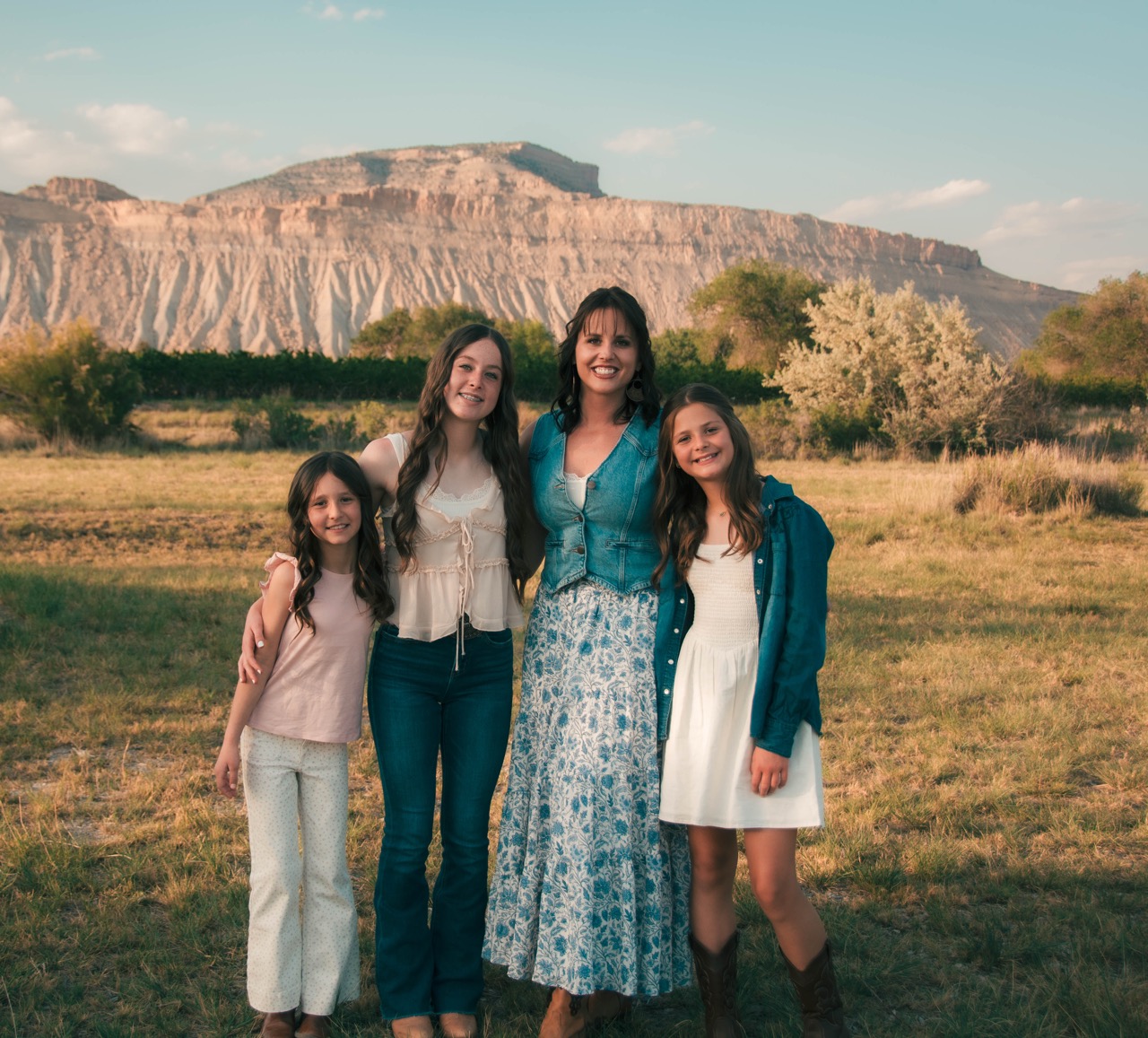 Mother and three daughters standing together with the Bookcliffs mesa behind them